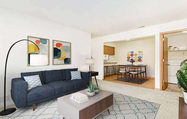 A living and dining room with a couch, table, and a rug at Tanglewood Apartments, Oak Creek