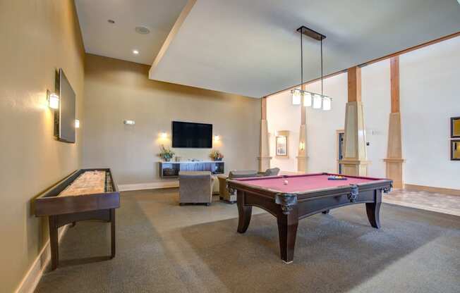 a spacious game room with a pool table and a foosball table