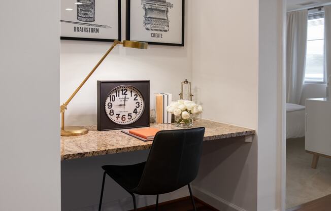 a desk with a clock and a chair in a living room