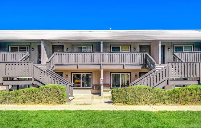 A building with a grey facade and a green lawn in front.