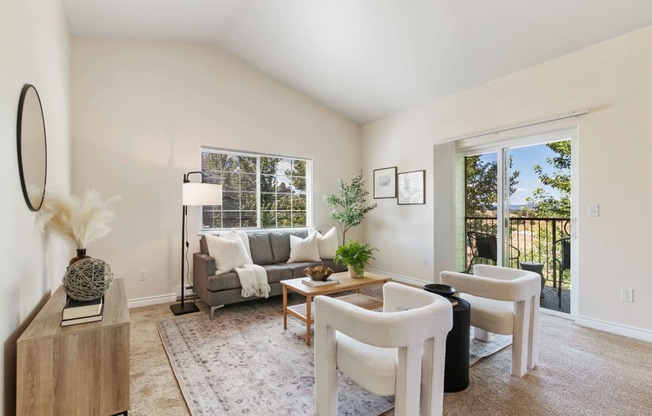 a living room with white furniture and a large window