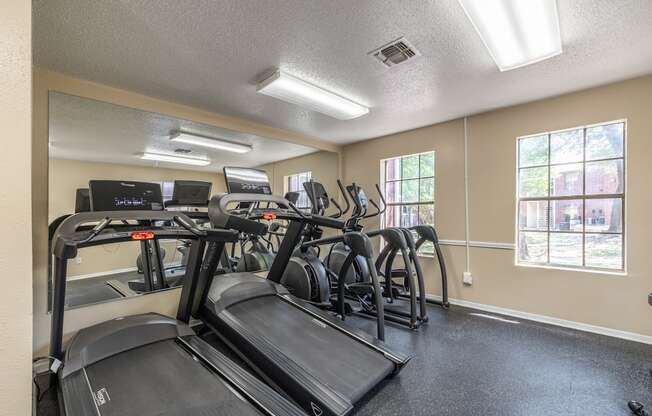 A gym with treadmills and elliptical machines.
