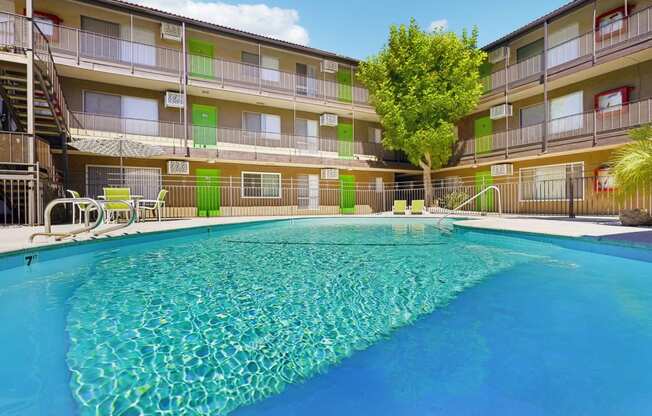 a resort style pool is in front of an apartment building