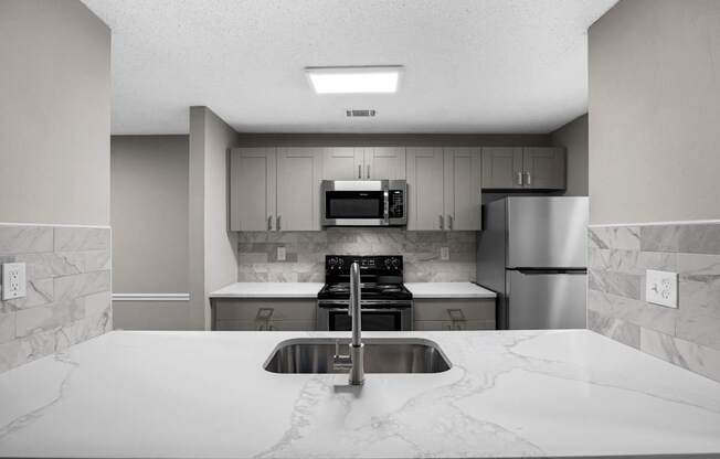 A kitchen with a sink, stove, and refrigerator.