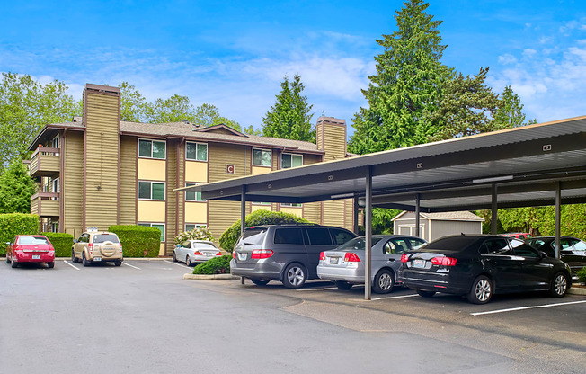 a parking lot with covered parking in front of Heritage Grove Apartments in Renton, WA