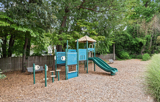 a playground with a swing set and slides in a park