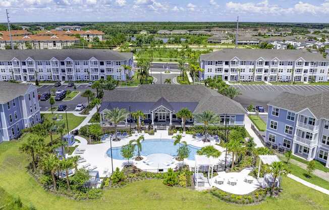 A large resort with a pool and palm trees.