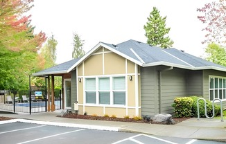 A small building with a grey roof and a white door.