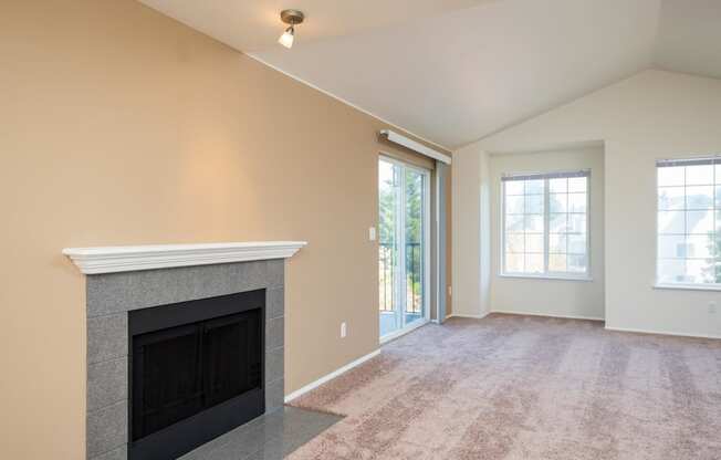 the living room has a fireplace and a door to the patio