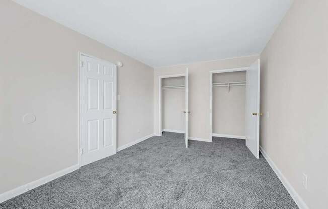 A room with a carpeted floor and two doors at Highland Ridge Apartments, Capitol Heights, MD, 20743