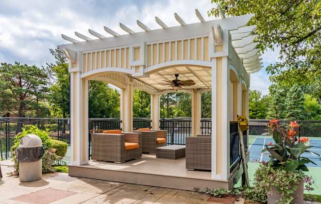 a gazebo with a seating area and a pool in a backyard
