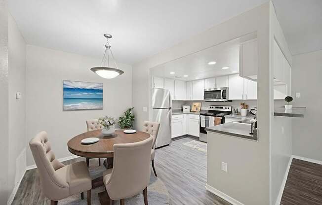 A modern kitchen with a dining table and chairs.
