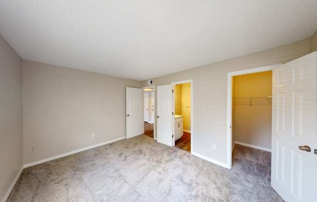 a bedroom with a bathroom in the background