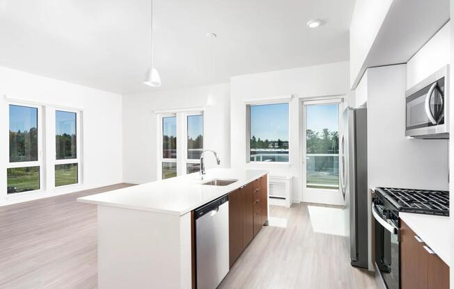This open-concept apartment features a chef-ready kitchen with a gas range, sleek stainless steel appliances, and airy living spaces.