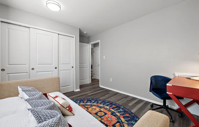 a living room with a couch and a chair and a desk