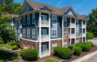 an apartment building with brick and blue exterior and balconies