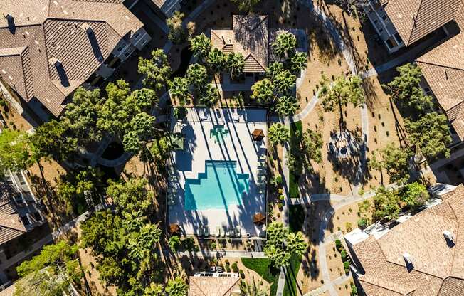 A swimming pool surrounded by trees and buildings.