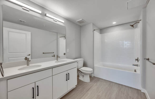 A white bathroom with a sink, toilet, and bathtub.