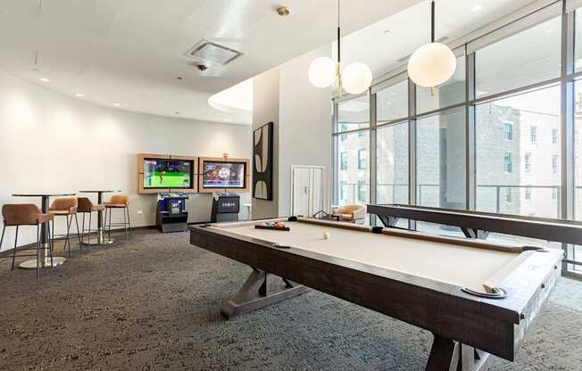 A room with a pool table and a television.