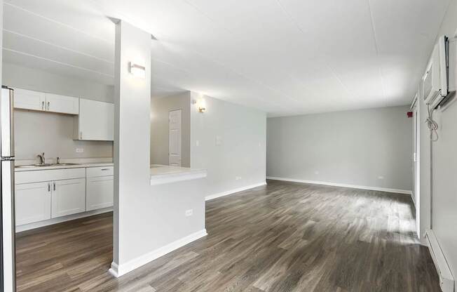 A kitchen with white cabinets and a refrigerator.