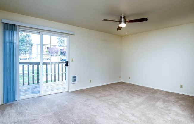 Large living area with ceiling fan and access to balcony/patio