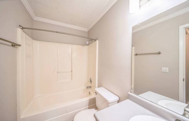 A white bathroom with a toilet, sink, and shower.