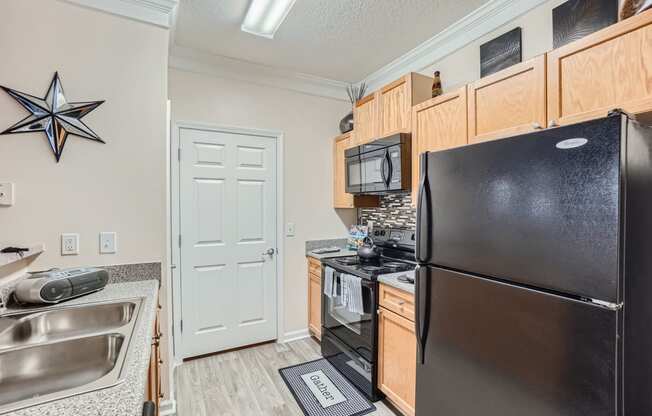 a kitchen with stainless steel appliances and a black refrigerator