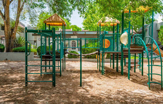 A playground with a green slide and a yellow top.