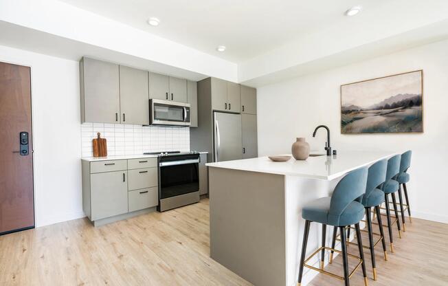 Premium homes feature oversized quartz islands with ample seating, contemporary flat-panel cabinetry, stainless steel appliances, and designer finishes that create a stylish space for cooking, dining, and entertaining.