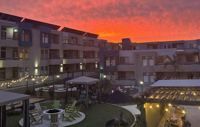 a view of the sunset over an apartment complex with a courtyard
