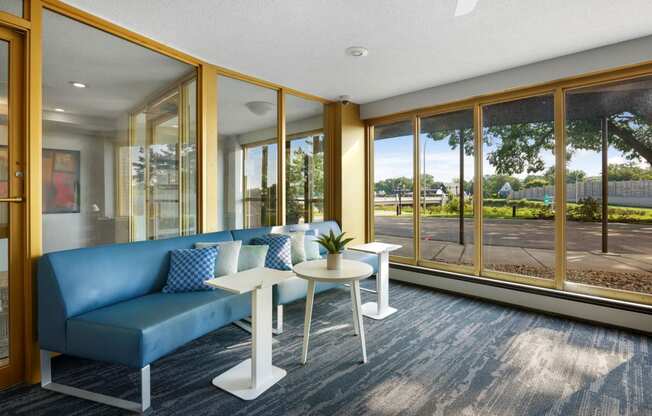 a living room with a blue couch and tables