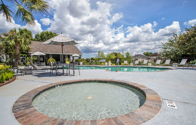 In Ground Hot tub with View of the Pool with chairs and an umbrella at Reserve by the Lake, Texas