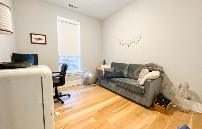 a living room with hardwood floors and a gray couch