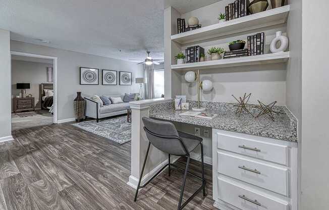 A kitchen with a desk and a chair in front of it.