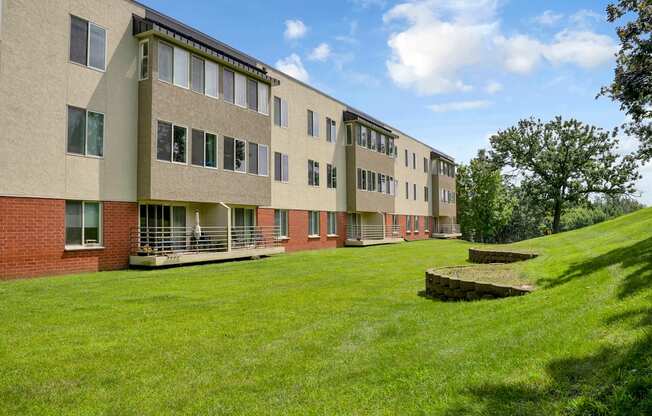 A long building with a green lawn in front.
