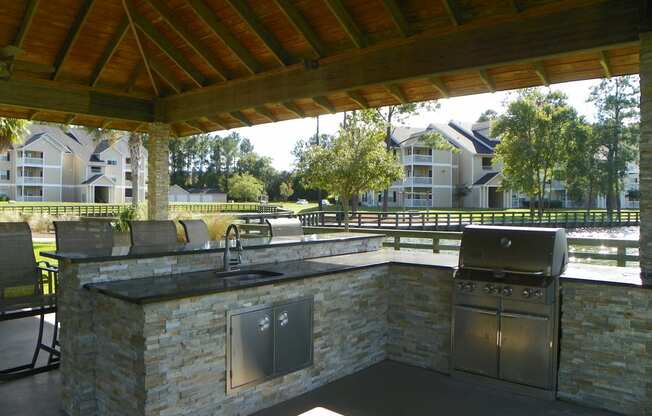 an outdoor kitchen with a grill  and sink