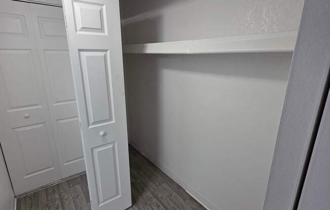 A white door is open in a room with grey flooring.