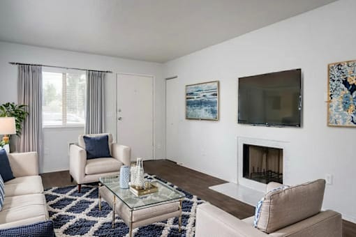 A living room with a fireplace, two chairs, and a coffee table.