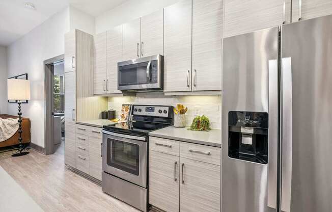 A modern kitchen with stainless steel appliances and white cabinets.