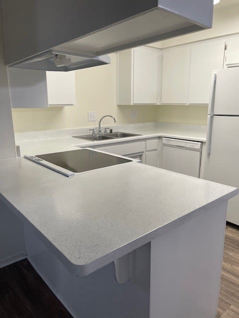 an empty kitchen with a counter top and a sink