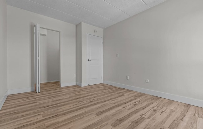 an empty living room with wood flooring and white walls