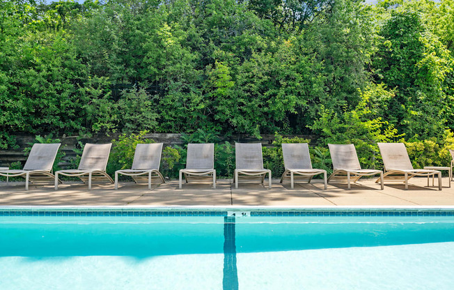 a group of lounge chairs next to a swimming pool