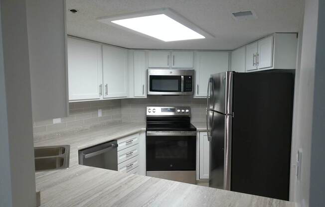 A kitchen with a black refrigerator, stove, and oven.