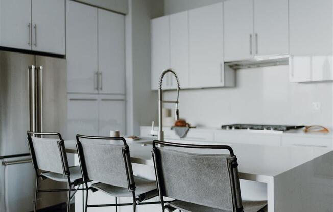 a white kitchen with white cabinets and a white table