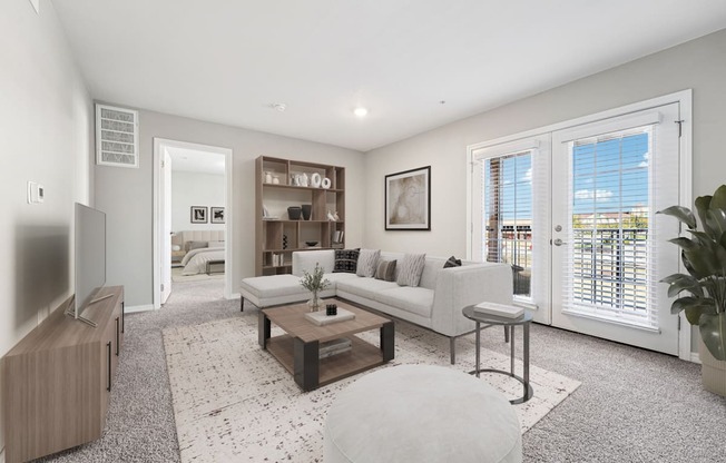 A living room with a white couch, a coffee table, and a large window with blinds.