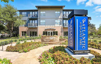 A large building with a sign that says "Atlantis Highland Park Apartment Homes".