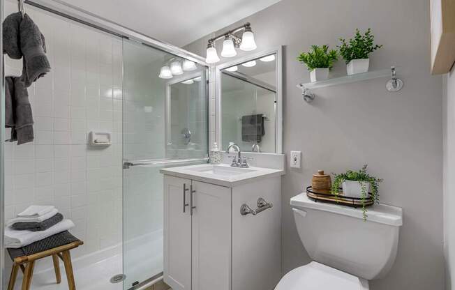 A white toilet sits next to a white sink in a bathroom.