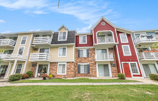 An apartment building with balconies and flower pots in front at Apple Ridge Apartments, Michigan, 49534