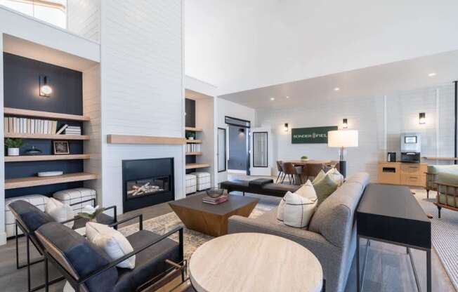 a living room with a couch and a table and a fireplace at Sonder Fields in Happy Valley, OR
