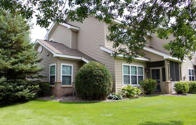 exterior of townhome with screened in porch and landscaping